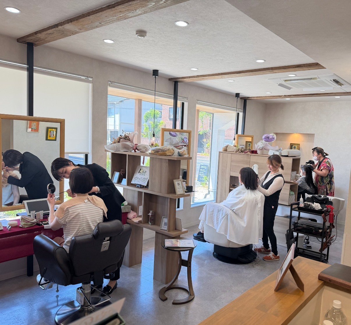 スタッフがお客様の施術をしている、明るく開放的な店内の様子