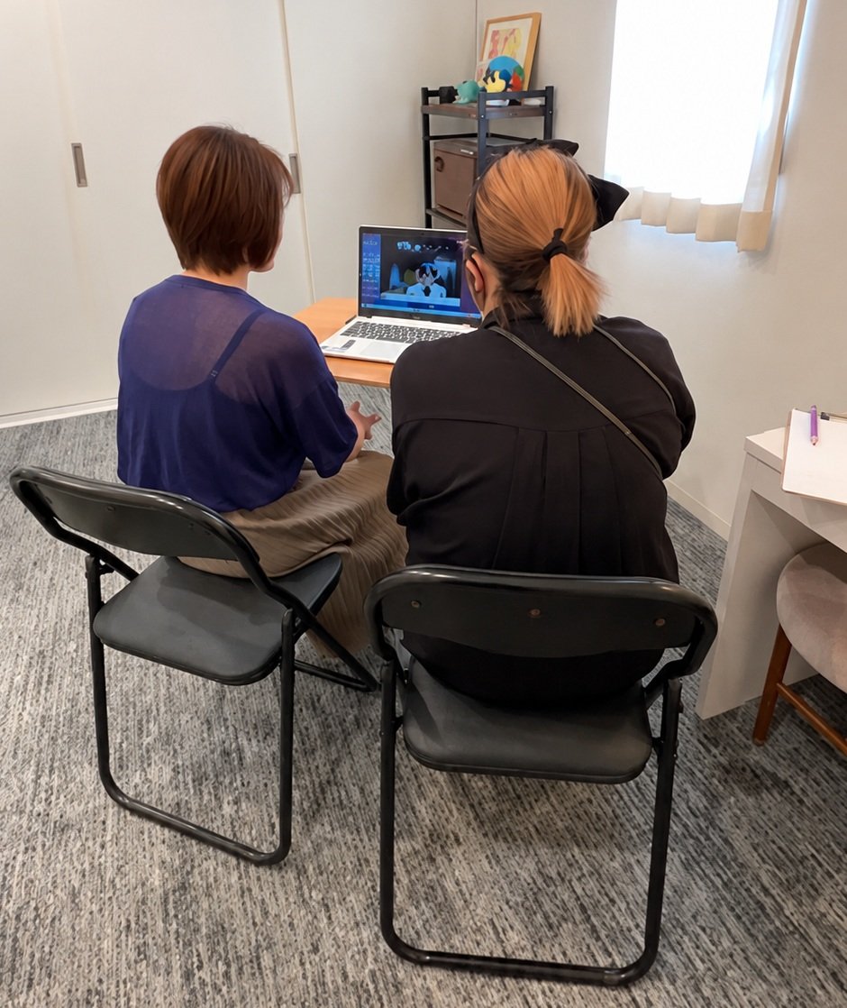 お客様とスタッフが並んで座り、ノートパソコンでオンライン診療を受けている様子